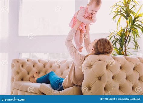 Cute Baby Smiling While Her Mother Holding Her In The Air Stock Photo