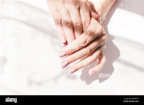 Well Groomed Hands Of An Old Elderly Woman With A Beautiful Natural Manicure On A White