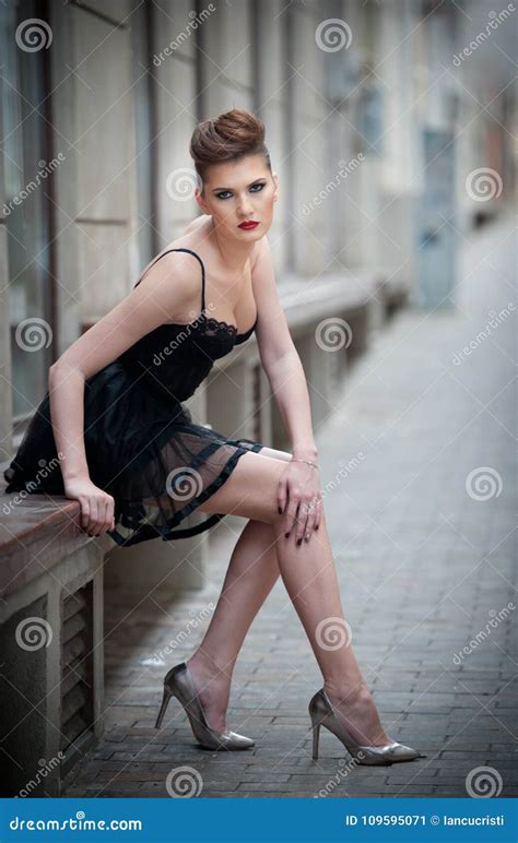 Sensual Girl With Long Legs Short Black Dress And High Heels Sitting On The Benchhandsome Girl