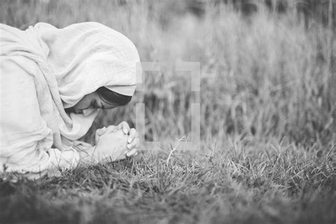 woman of biblical times kneeling in prayer — photo — lightstock