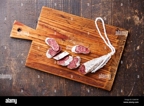 Salami Sausage On Wooden Cutting Board On Dark Background Stock Photo