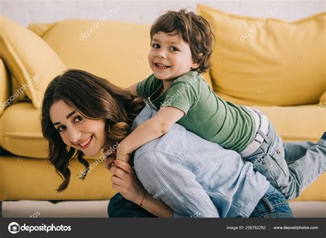 Sonriente Madre Hijo Jugando Juntos Cerca Sofá Amarillo — Foto De Stock