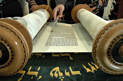 Torah Reading In A Synagogue With A Hand Holding A Silver Pointer