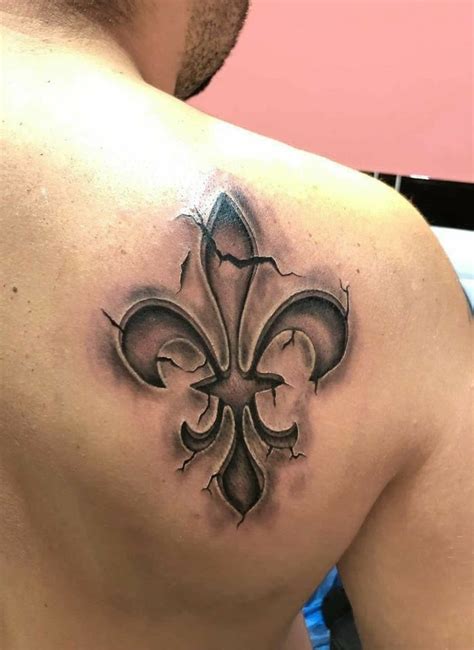 A Man With A Tattoo On His Back Has A Fleur De Lis Design