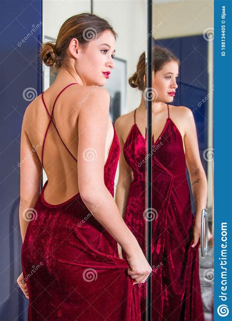 Retrato De Una Bella Joven Vestida De Rojo Con La Espalda Desnuda Frente Al Espejo Imagen De