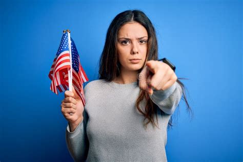 Young Beautiful Brunette Patriotic Woman Holding American Flag Celebrating 4th Of July Pointing