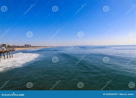 A Majestic Shot Of The Large Waves Breaking In Vast Blue Ocean Water With A Sandy Beach Filled