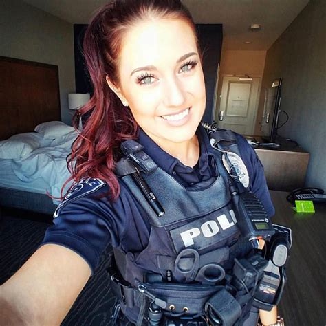 A Woman In Police Uniform Taking A Selfie