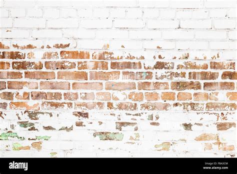 Old Red Brick Wall With Damaged White Paint Layer Closeup Background