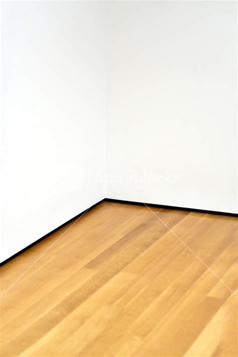 The Corner Of An Empty Room With Wood Floors And White Walls Lots Of