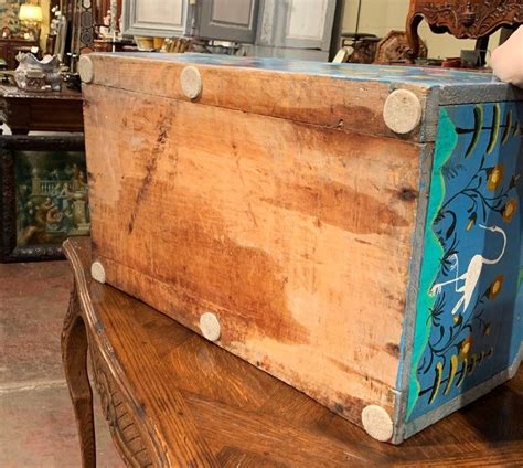 An Old Trunk Sitting On Top Of A Wooden Bench In A Room Filled With