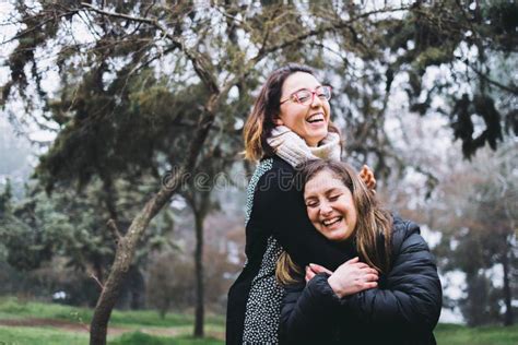 Lesbian Couple Hugging And Laughing At The Park Copy Space Stock