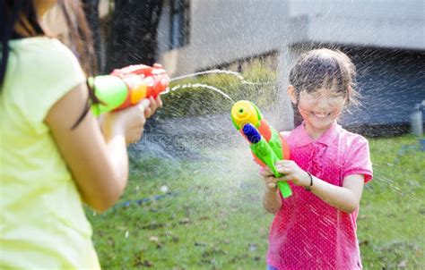 Happy Little Girls Playing Water Guns In The Park Stock Image Image