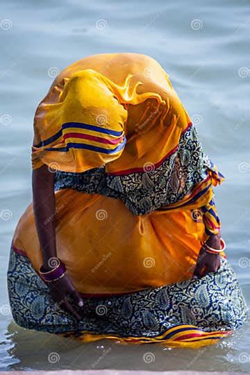 Life On The Ganges Woman In A Bright Yellow Or Orange Sari Bathing In The Ganges As Religious
