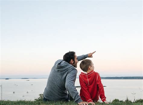 Father Sitting Together With Son Pointing Into The Sky By Stocksy Contributor Cara Dolan