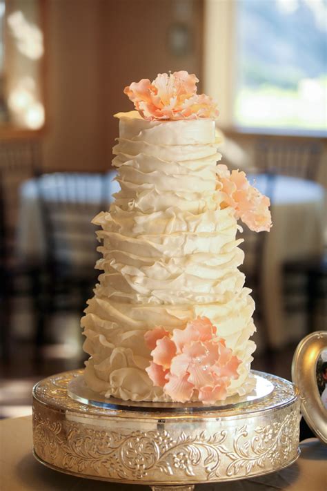 White Ruffled Wedding Cake With Peach Sugar Flowers