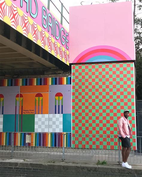 A Man Standing In Front Of A Colorful Building