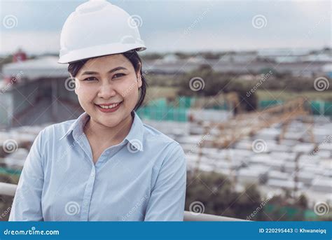 Female Civil Engineer In Safety Hard Hat Standing Against With