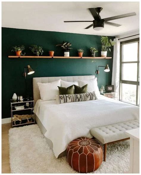 A Bedroom With Dark Green Walls And White Bedding Potted Plants On The