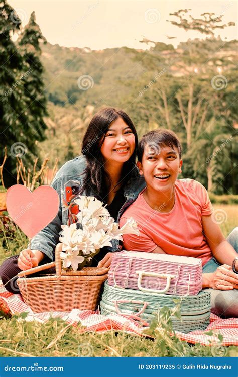 A Sweet Young Asian Couple Having A Picnic In The Park Like A Lovers