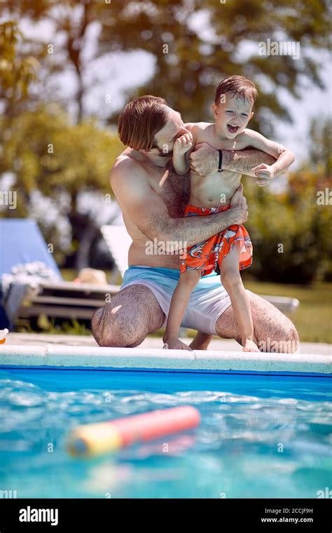 Dad And Happy Son Have Fun And Relaxing In Outdoor Swimming Pool Stock