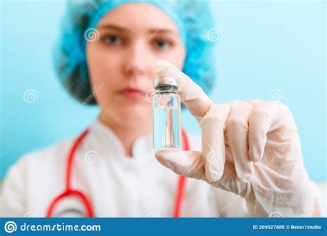Doctor Woman Nurse Holding Coronavirus Vaccine In Hand In Glove