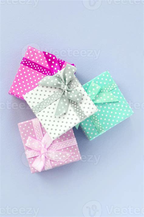Pile Of A Small Colored Gift Boxes With Ribbons Lies On A Violet
