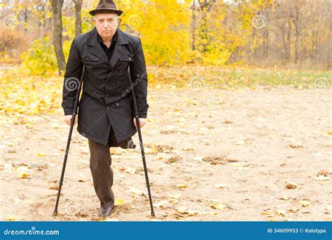 One Legged Man Walking With Crutches In The Park Stock Image Image Of