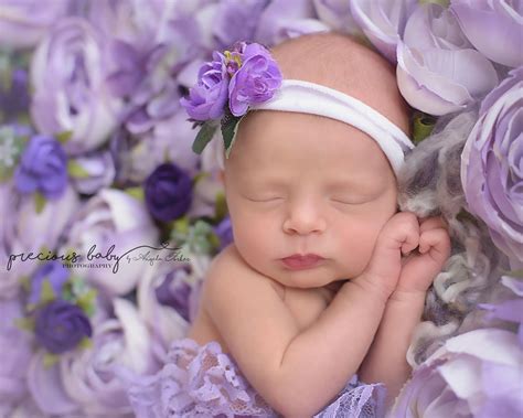 Beautiful Newborn Baby Girl Sleeping On A Purple Flower Blanket With