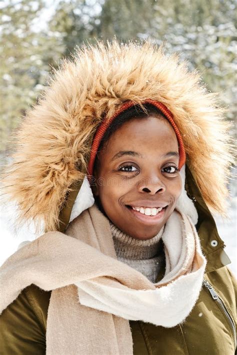 Cheerful Young Black Woman In Warm Winter Jacket With Hood Looking At