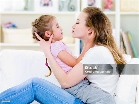 Mother Kissing Her Daughter Stock Photo Download Image Now 20 24