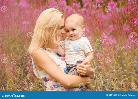 La Belle Maman Blonde Mince étreint Le Petit Garçon Adorable Sur Le Dos Image stock Image du
