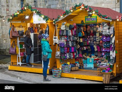 Market Stall Holders On Hat And Mittens Stall And Bags Stall At