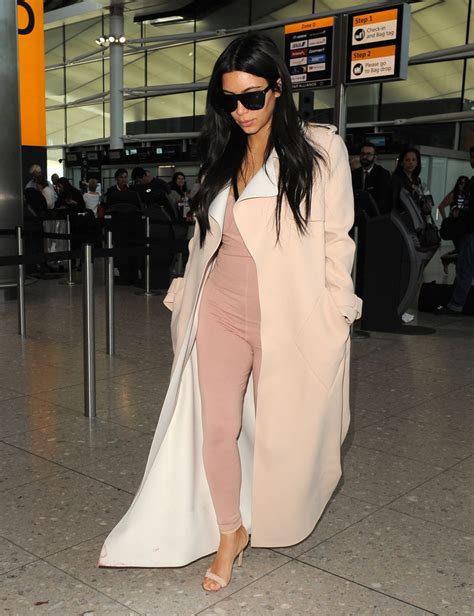 Solo Kim Kardashian Shows Off Her Curves As She Jets Out Of London In