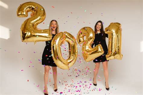 Premium Photo Cheerful Caucasian Sisters Holds Big Gold Baloons With