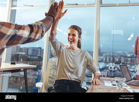 Business Colleagues Giving High Five To Each Other In Office Team