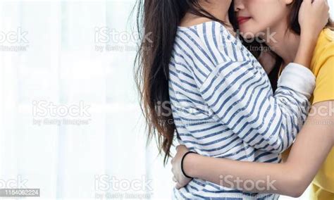 Close Up Of Two Asian Lesbian Women Looking Together In Bedroom Couple