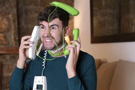 Messy Man Using Two Landline Telephones At The Same Time Stock Image