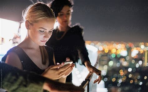 View Young Woman Busy On Her Smart Phone At Rooftop Party By Stocksy Contributor Jovo