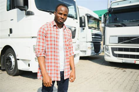 Front View Young African Truck Driver Is With His Vehicle At Daytime