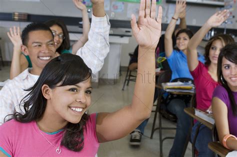 High School Students Raising Their Hands In Class Stock
