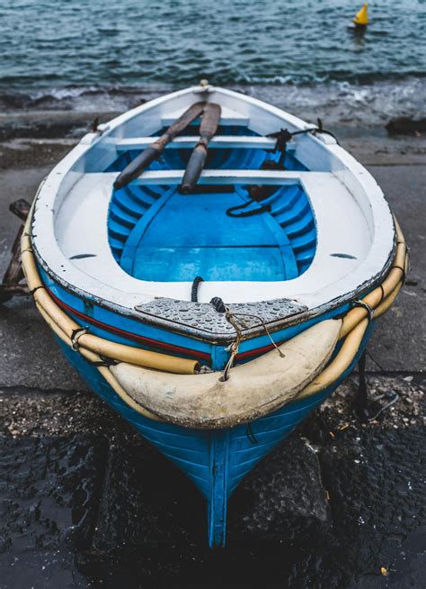 White And Blue Wooden Boat On Seashore · Free Stock Photo