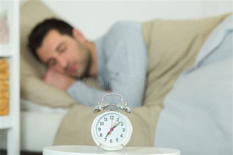 Beautiful Young Man Waking Up With Mobile Alarm Clock Stock Photo