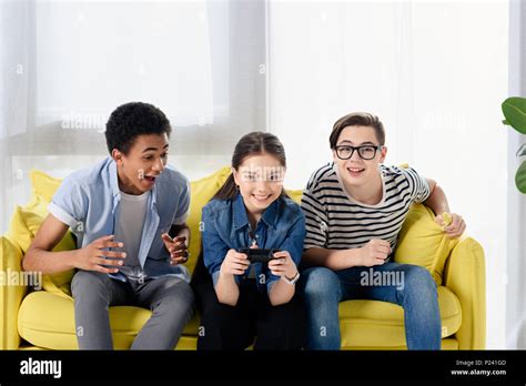 Multicultural Teen Boys Supporting Friend Playing Video Game At Home
