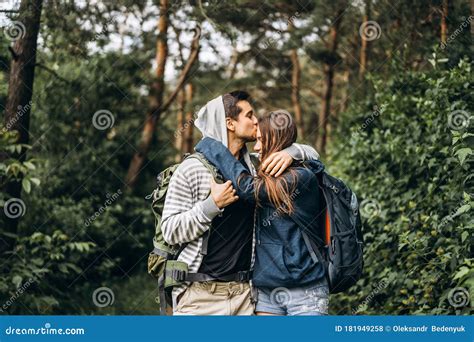 Young Couple With Backpacks On Their Backs Smiling And Walking In The
