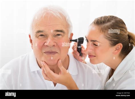 Doctor Looking At Patients Ear Through Otoscope Stock Photo Alamy