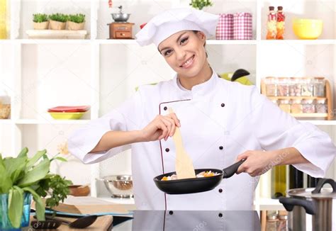 Young Woman Chef Cooking In Kitchen Stock Photo By ©belchonock 21043427
