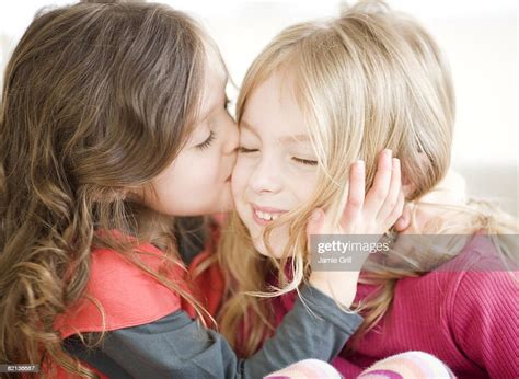 Girl Kissing Sister On Cheek Stock Foto Getty Images