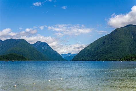 Blue Mountain Lake With Green Mountains Blue Sky And White Clouds Stock