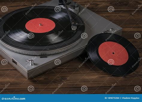 Two Red Vinyl Discs And A Vinyl Record Player On The Table Stock Photo